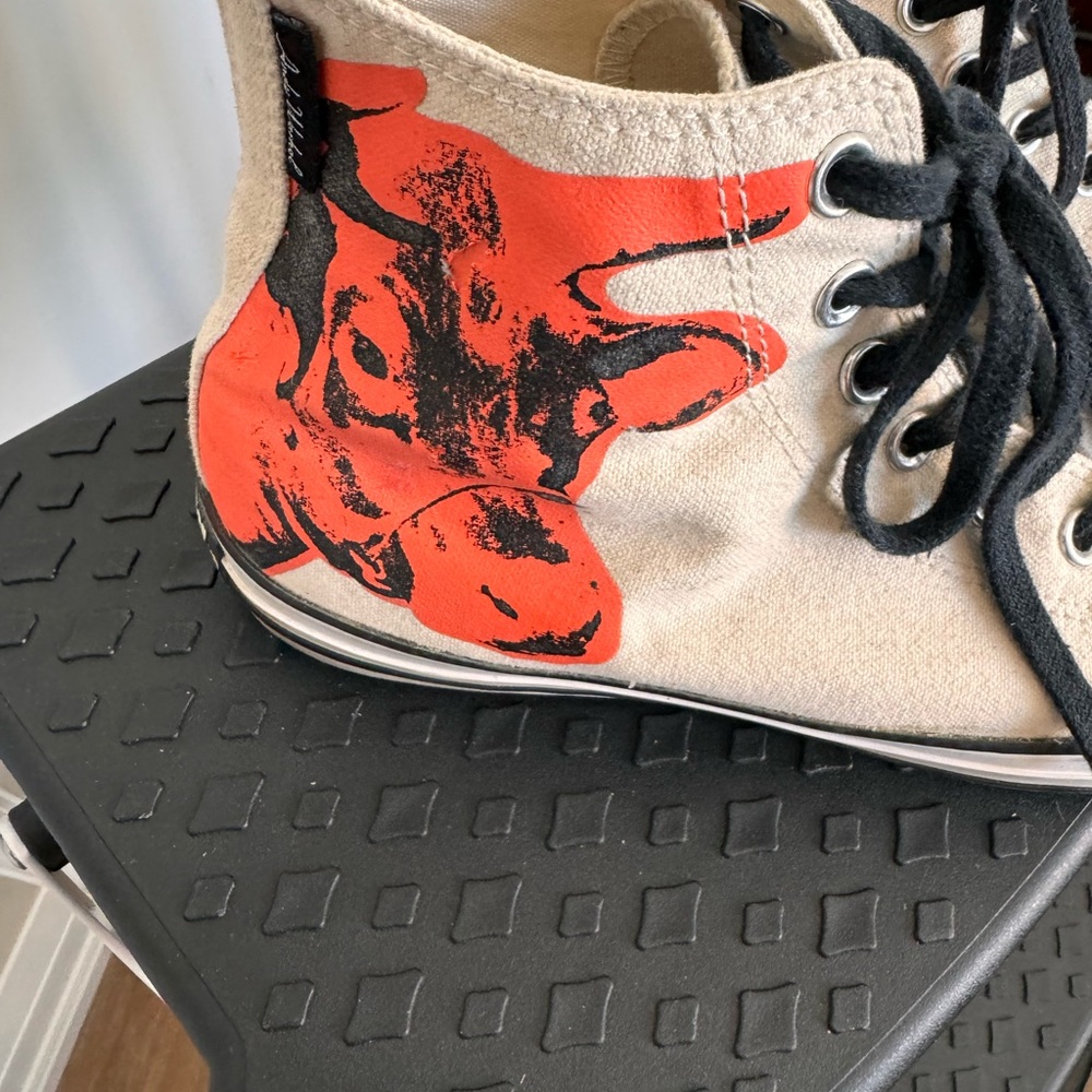 Cream canvas All Star high top with Andy Warhol orange cow on outside ankles.